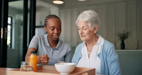 Caregiver assisting resident with a meal